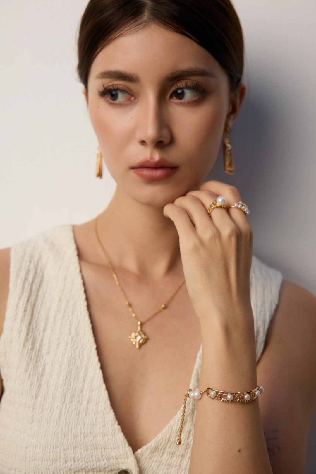 Long freshwater pearl window drop earring worn beside a light open neckline