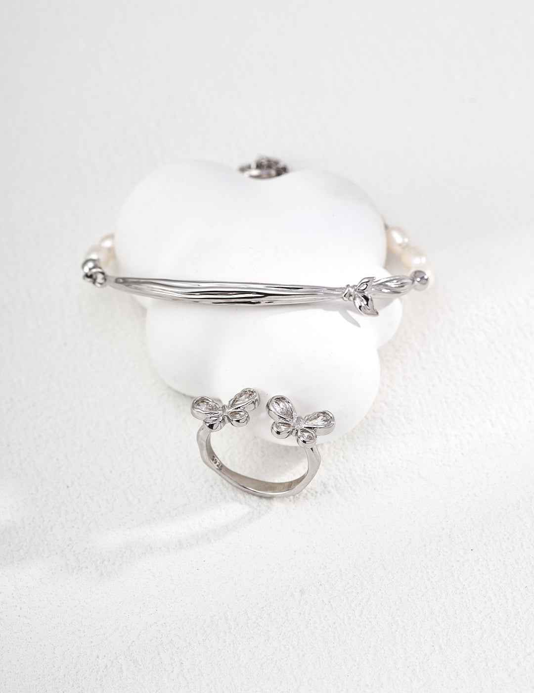 Close-up of sterling silver butterfly ring showing CZ accents and wing-like curves