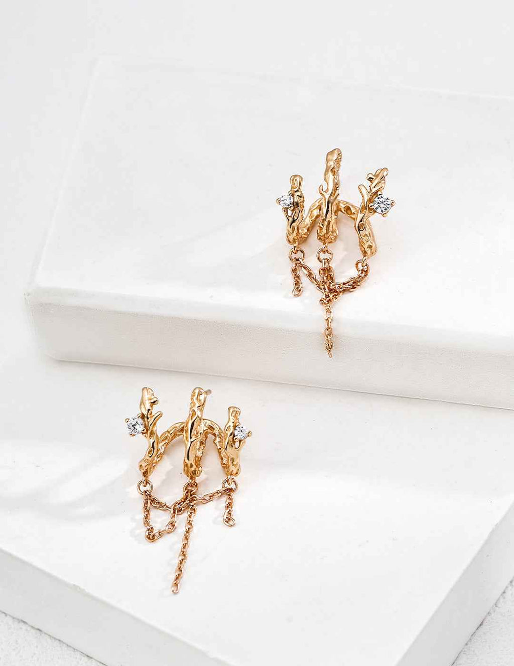 Pair of 925 sterling silver branch-inspired CZ earrings displayed