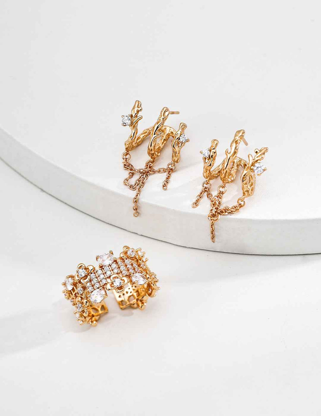 Close-up of sterling silver branch earrings showing asymmetric silhouette and CZ detail