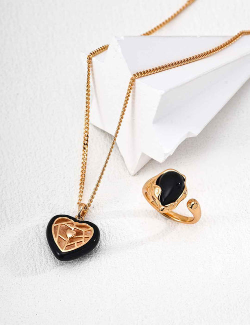 Close-up of black enamel heart pendant showing contrast with gold-tone frame