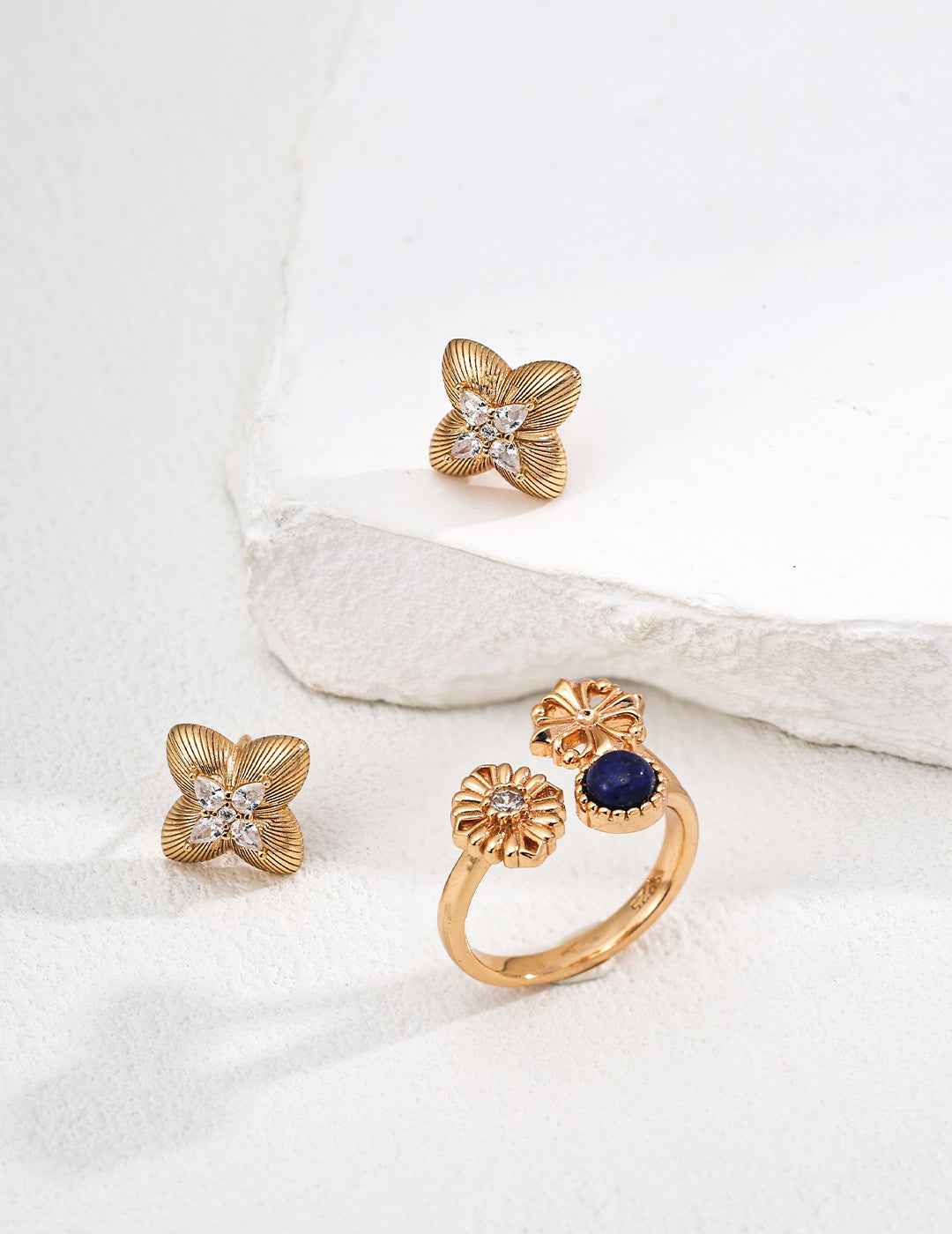 Close-up of sterling silver clover CZ stud earrings showing dimensional form and stone detail