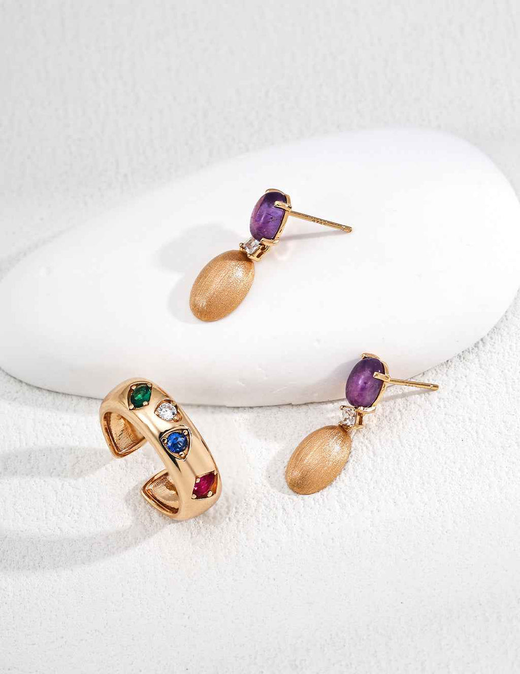 Close-up of sterling silver amethyst drop earrings showing stone detail and gold-tone frame