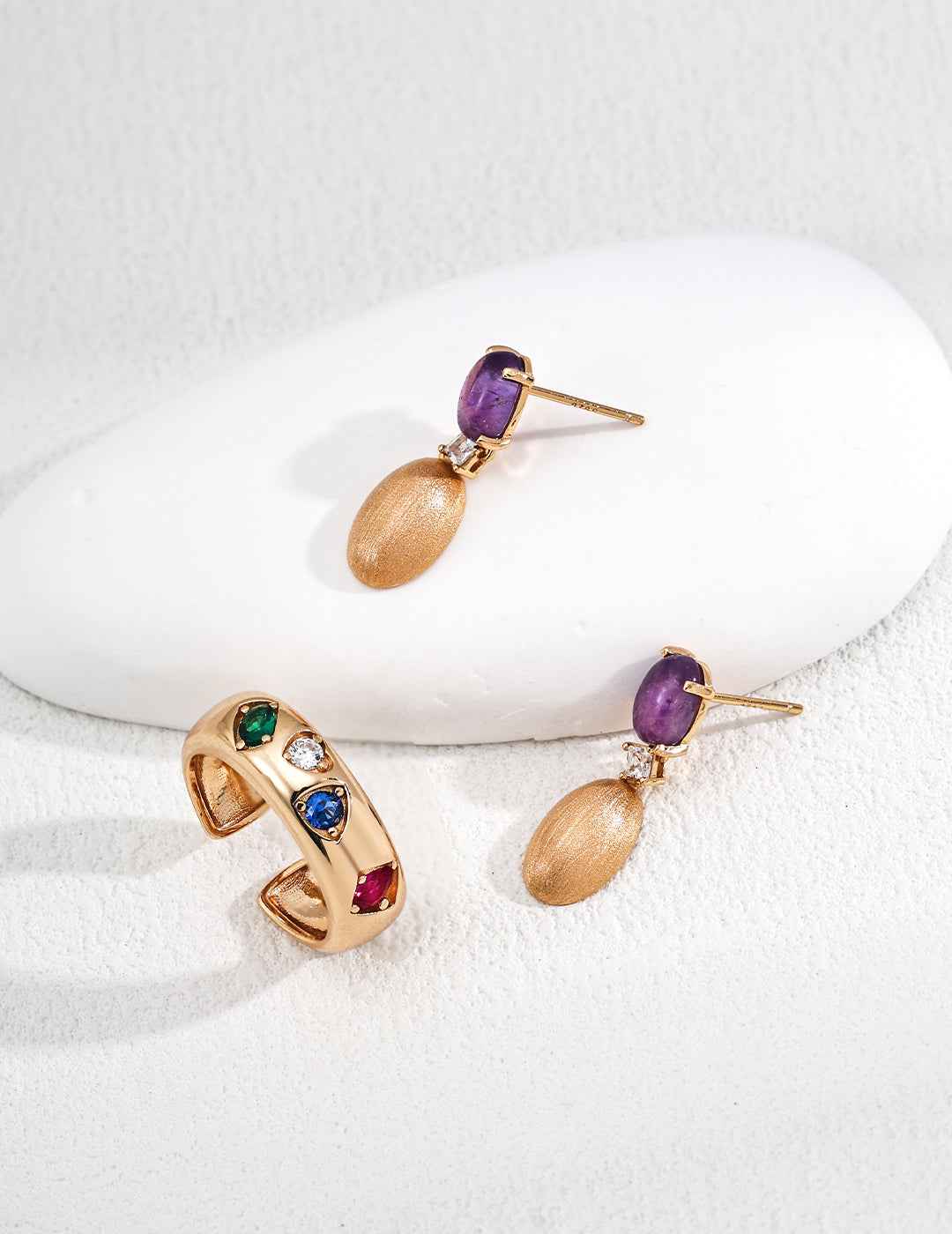 Close-up of sterling silver amethyst drop earrings showing stone detail and gold-tone frame