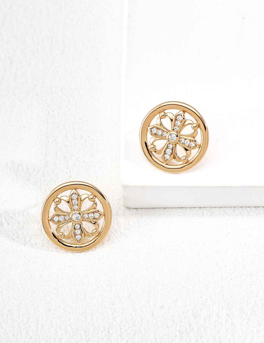 Close-up of sterling silver cross motif stud earrings showing openwork frame and zirconia detail
