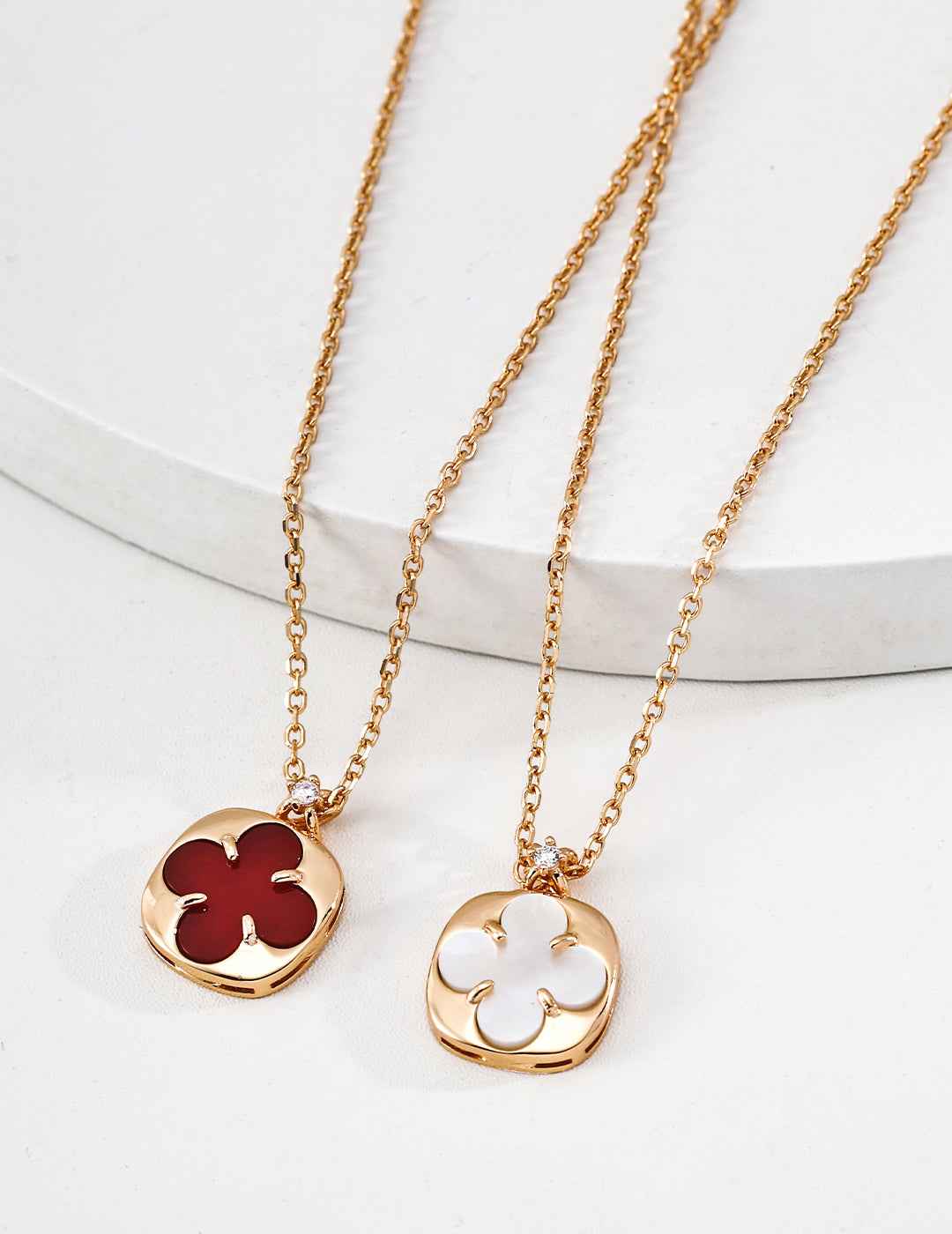 Close-up of sterling silver clover pendant showing polished natural stone inlay and gold-tone frame