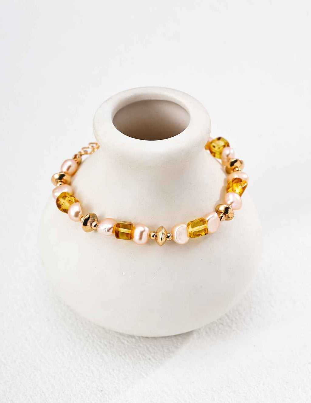 Full view of beaded bracelet with alternating amber and pearl beads, gold-tone clasp