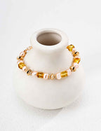 Full view of beaded bracelet with alternating amber and pearl beads, gold-tone clasp