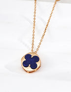 Close-up of sterling silver clover pendant showing polished stone inlay and gold-tone frame detail