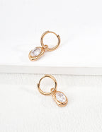 Close-up of sterling silver drop hoop earring showing CZ detail and metal frame