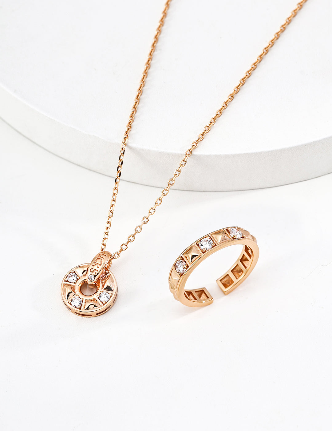 Close-up of sterling silver coin pendant showing CZ stones and dimensional engraved surface
