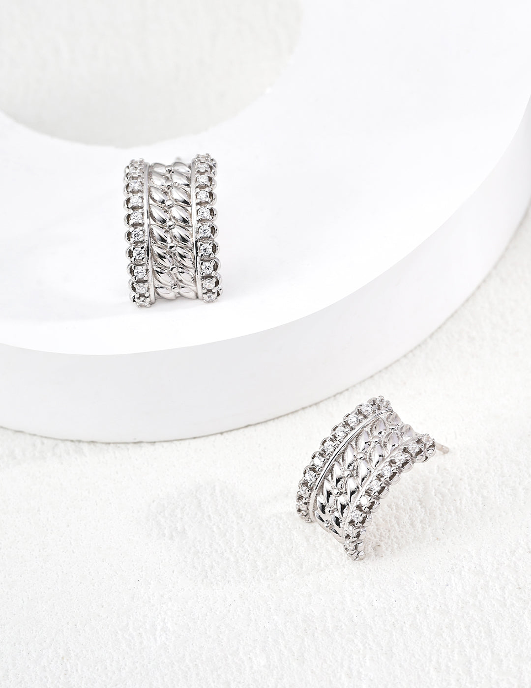 Pair of 925 sterling silver CZ textured stud earrings, front view