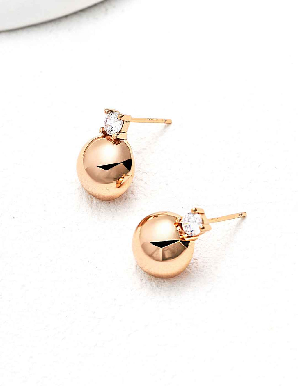 Close-up of sterling silver CZ ball stud earring showing smooth spherical form