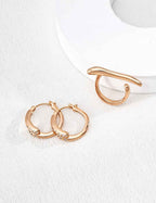 Close-up of sterling silver twisted texture hoop earring showing surface detail and CZ accent