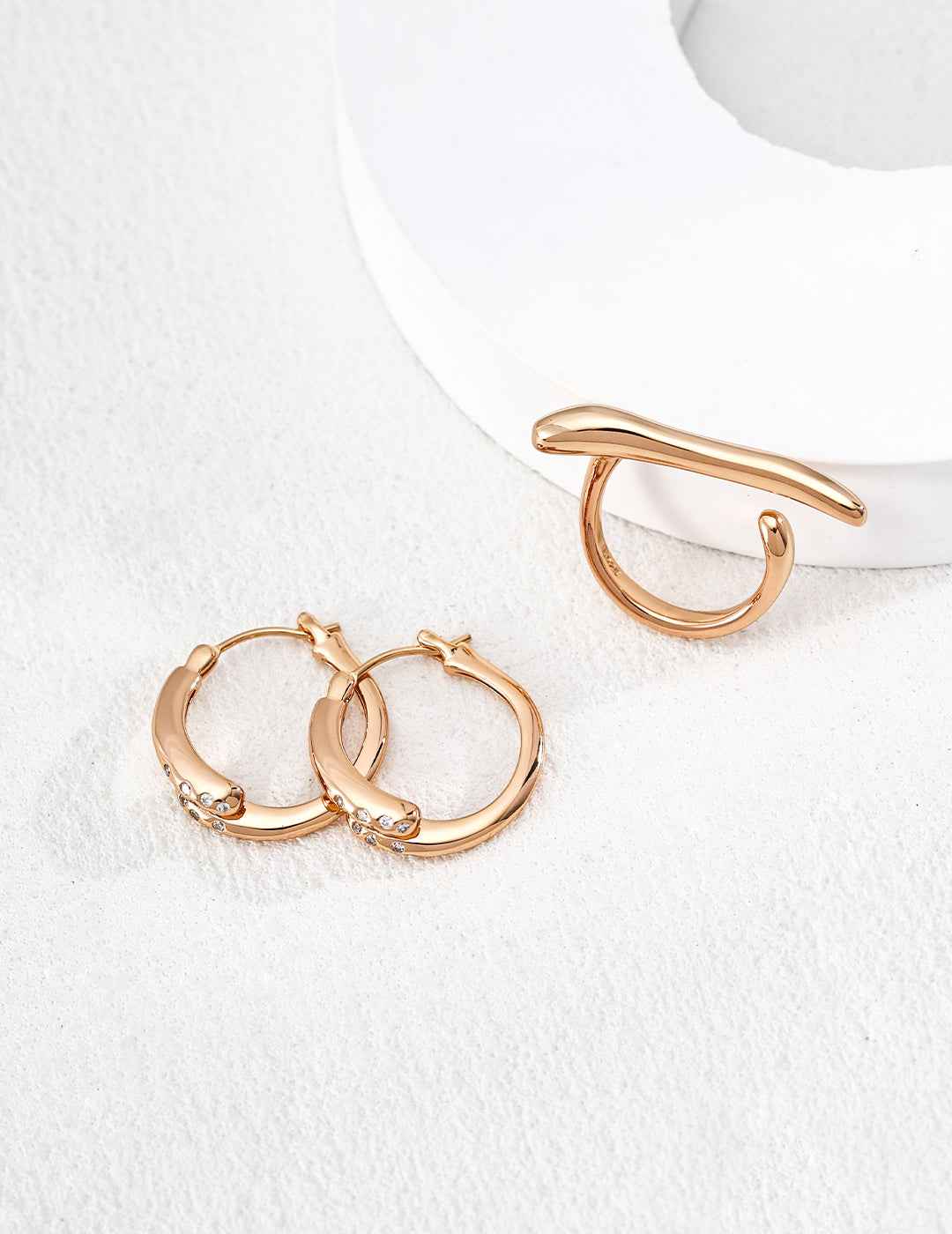 Close-up of sterling silver twisted texture hoop earring showing surface detail and CZ accent