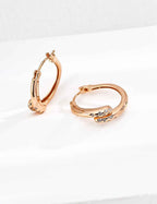 Pair of 925 sterling silver cubic zirconia twisted hoop earrings, front view