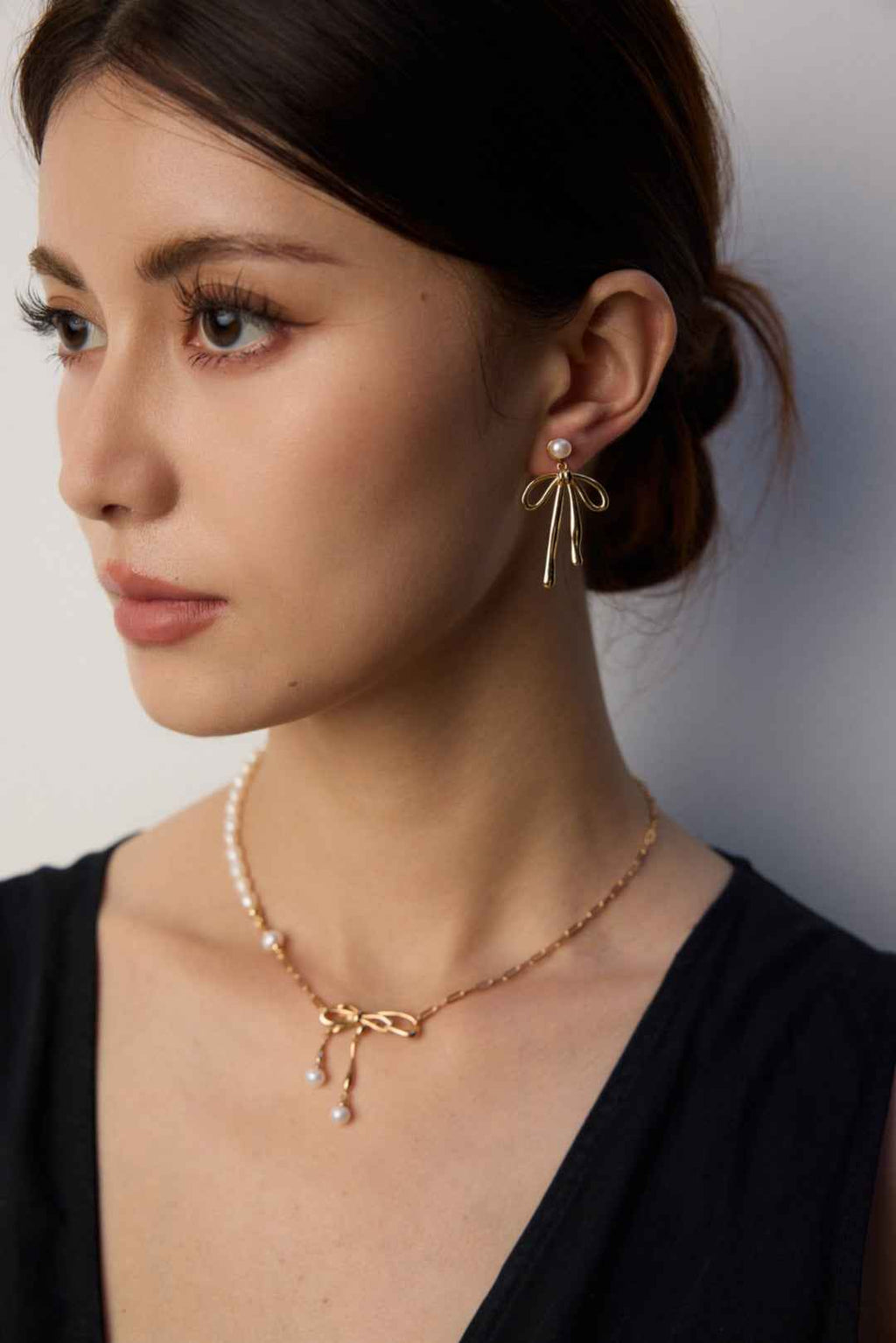 Pair of 925 sterling silver bow and pearl drop earrings displayed