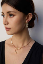 Pair of 925 sterling silver bow and pearl drop earrings displayed