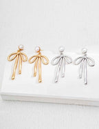 925 sterling silver bow drop earrings with pearl accent, worn on ear